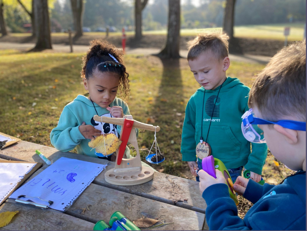 children explore scales on picnic table in park